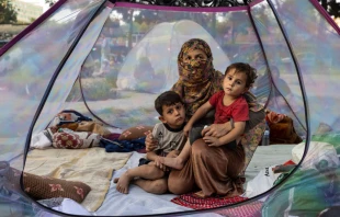An Afghan mother and her children rest in a tent at a makeshift IDP camp in Share-e-Naw park in Kabul. Paula Bronstein/Getty Images.