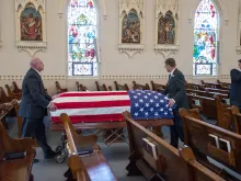 A coffin containing the remains of Fr. Emil Kapaun is taken to the front of St. John Nepomucene Church in Pilsen, Kan., Sept. 25, 2021.