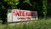 Grafitti on a sign for All Saints Catholic Church in Portland, Oregon, June 25, 2022.