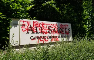 Grafitti on a sign for All Saints Catholic Church in Portland, Oregon, June 25, 2022. All Saints Catholic Church