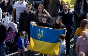 A group of people in St. Peter's Square hold a Ukrainian flag during Pope Francis' Angelus on Sunday, March 20, in Vatican City. Vatican Media