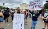 Anna Lulis from Moneta, Virginia, (left) who works for the pro-life group Students for Life of America, stands beside an abortion rights demonstrator outside the U.S. Supreme Court in Washington, D.C., on June 24, 2022, after the court's decision in the Dobbs abortion case was announced.