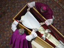 Before the wooden coffin is closed, Benedict XVI’s personal secretary Archbishop Georg Gänswein and Monsignor Diego Giovanni Ravelli, the Vatican’s lead master of ceremonies for papal liturgies, place a white veil over the late pope’s face. The action on Jan. 4, 2023, is part of the funeral rites for popes.