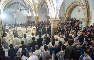 The Catholic faithful gathered in the Cenacle in Jerusalem for the Mass of the Lord's Supper that the Franciscan friars celebrated on Holy Thursday, March 28, 2024. The Cenacle is at the center of strong tensions and disputes regarding ownership and rights of access and celebration. An ancient tradition places King David’s tomb here and over the centuries Jews and Muslims have leveraged this to first expel the Franciscans and then to prevent Christian worship, which they deemed sacrilegious. Credit: Marinella Bandini
