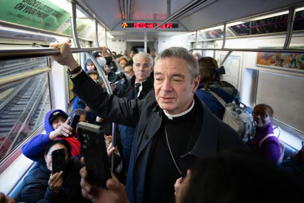 Bishop Robert Brennan takes a ride on the subway alongside other faithful heading to the Diocese of Brooklyn’s Eucharistic Revival on April 20, 2024. Credit: Jeffrey Bruno
