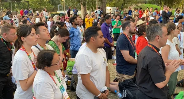 Pilgrims kneel in adoration at a World Youth Day event in Lisbon, Portugal, Aug. 2, 2023. The event was hosted by the U.S. bishops’ conference and featured a talk by Bishop Robert Barron culminating in a eucharistic procession and Holy Hour. Credit: Claudette Jerez/EWTN News video screen shot