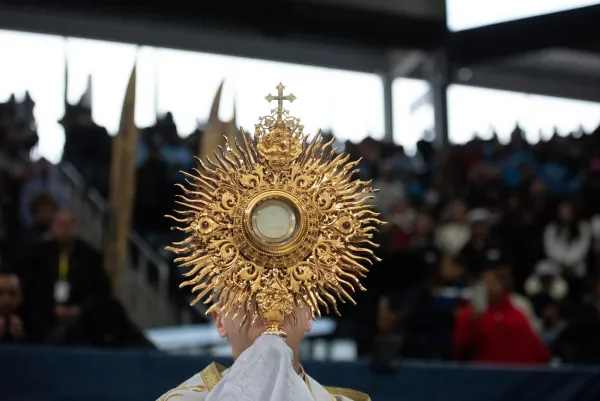 Bishop Robert Brennan carries the Blessed Sacrament during a Eucharistic procession at Louis Armstrong Stadium on April 20, 2024. Credit: Jeffrey Bruno