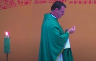 Fr. Robinson de Castro Cunha examines a bullet that landed at his feet during Mass January 31. YouTube screenshot