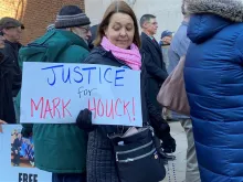 A woman attends a rally for Mark Houck outside the James A. Byrne United States Courthouse in Philadelphia on Jan. 24, 2023, while holding a sign that says “Justice for Mark Houck!”