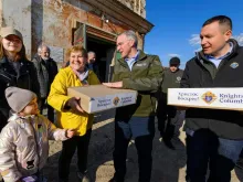 Supreme Knight Patrick E. Kelly, center, and Ukraine State Deputy Youriy Maletskiy give out Easter care packages to Ukrainian refugees in Rava-Ruska, Poland, in April 2022.