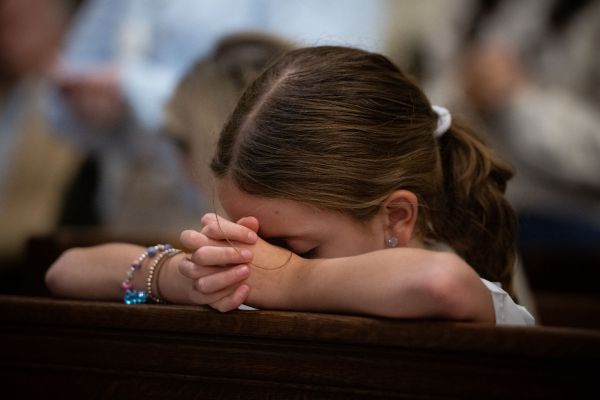 A young Massgoer prays at St. Patrick’s Cathedral in New York City before a Eucharistic procession through the streets Oct. 10, 2023. Credit: Jeffrey Bruno