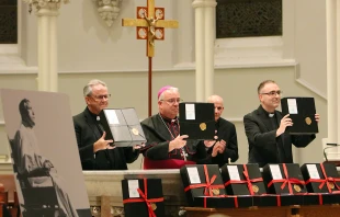 Father Thomas Dailey, O.S.F.S.; Philadelphia Archbishop Nelson J. Perez; Msgr. Gerald Mesure, archdiocesan chancellor; and Father Sean Bransfield, vice chancellor, hold the official documents for the canonization cause of Father Bill Atkinson during the closing ceremony on Oct. 19, 2021. Sarah Webb