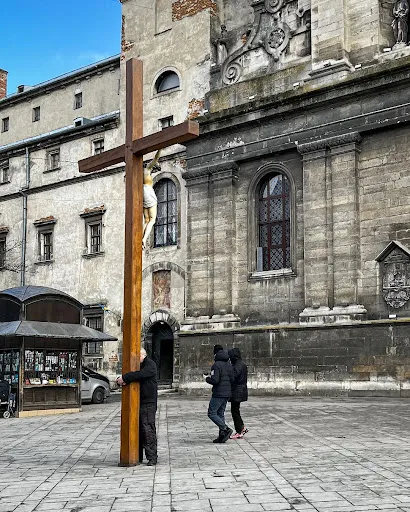 A man hugs a cross outside a monastery in Lviv, Ukraine, on Feb. 24, 2022, on the first day of Russia's invasion. Courtesy of Dennis Melnichuk