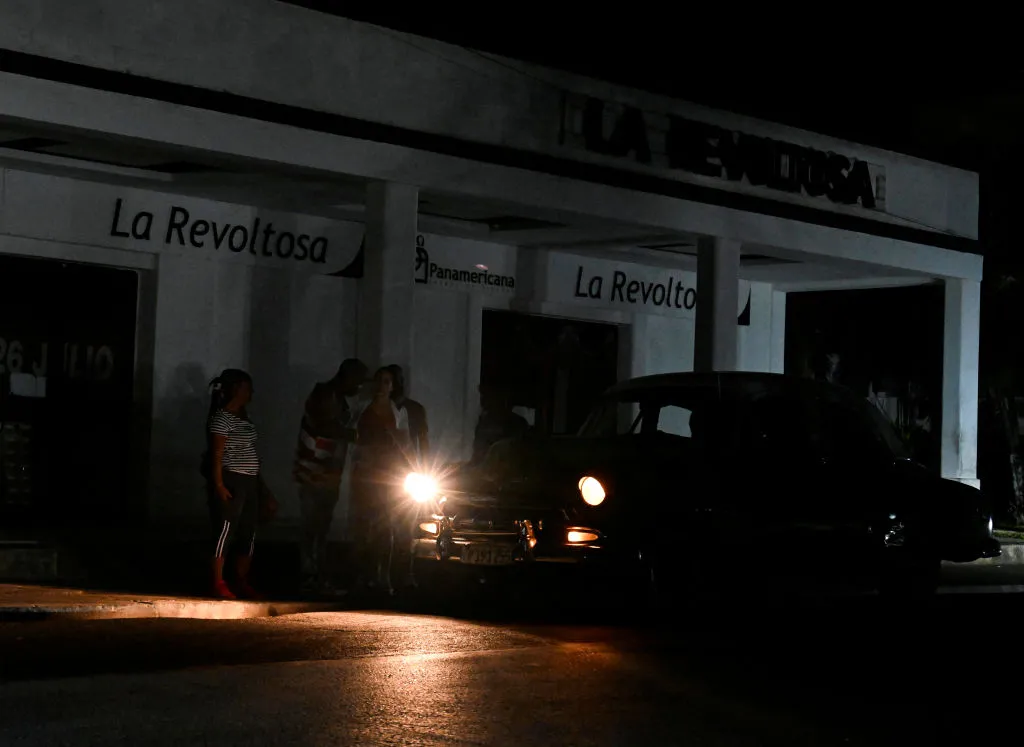 People use a car to light themselves on a dark street during a blackout in Bauta municipality, Artemisa province, Cuba, on March 18, 2024.?w=200&h=150