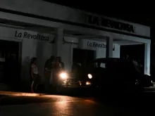 People use a car to light themselves on a dark street during a blackout in Bauta municipality, Artemisa province, Cuba, on March 18, 2024.