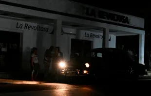 People use a car to light themselves on a dark street during a blackout in Bauta municipality, Artemisa province, Cuba, on March 18, 2024. Credit: YAMIL LAGE/AFP via Getty Images