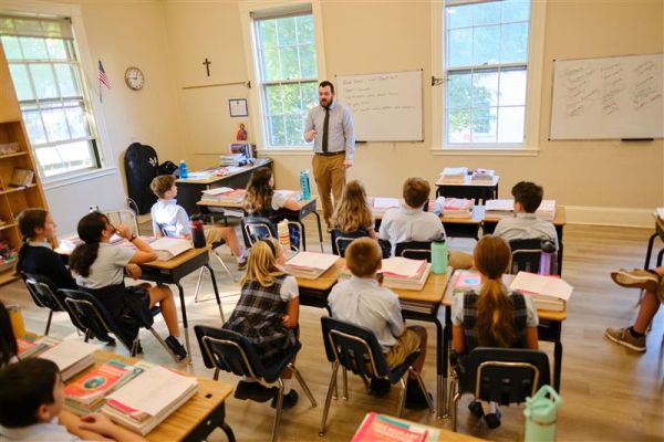 Teacher Zach Morris teaches sixth graders at St. Benedict Classical Academy in Natick, Massachusetts, in January 2024. Credit: George Martell