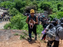 A migrant carries a baby in the Darien Province in Panama on Sept. 22, 2023. Hundreds of thousands of migrants have entered Panama through this jungle so far this year.