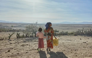 A woman and a girl in Tigray walk with supplies. The founder and CEO of the global school-feeding charity Mary’s Meals visited northern Ethiopia in March and confirmed reports of a widespread hunger crisis unfolding rapidly in Tigray in the aftermath of a two-year civil war and ongoing drought.  Credit: Armstrong Studios/2024