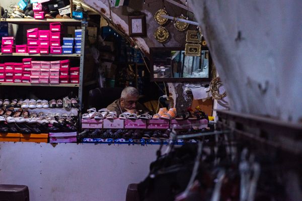 The owner of a shoe store sits behind the counter. “Since the beginning of the month, I haven’t sold anything," he told CNA. "People don’t even have money for food or to pay the bills; they’re not coming to buy shoes.” Credit; Marinella Bandini