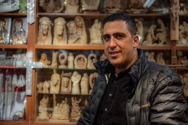 Roni Tabash in his store in Manger Square, Bethlehem, which has been in his family for almost a century. They sell handmade items crafted by local artisans. Today, Tabash carries on the business in the footsteps of his father and grandfather. Nov. 18, 2023. Credit: Marinella Bandini
