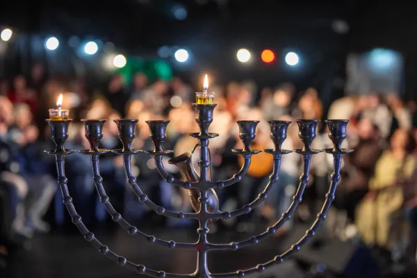 The first Hanukkah candle is lit on the special nine-branched candelabrum that is lit during the Hanukkah feast, which began this year on the evening of Dec. 7, 2023, two months after the outbreak of Israel's war with Hamas. Credit: Marinella Bandini