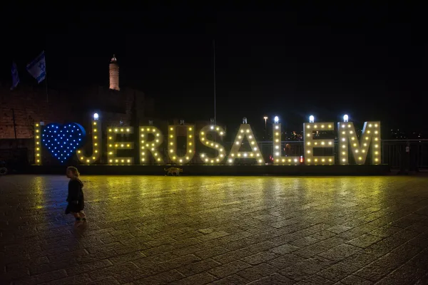 The municipality of Jerusalem has arranged a special setup in front of Jaffa Gate, one of the main entry points to the Old City. In the plaza beneath the walls, the word “JERUSALEM,” composed of nine letters, has become a large hanukkiah. Credit: Marinella Bandini