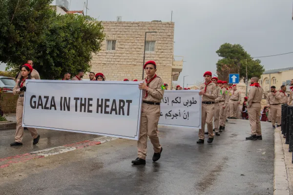The Terra Sancta Scouts of Bethlehem carry a banner that reads "Gaza in the heart" as part of the Latin Patriarch of Jerusalem's Christmas Eve procession to the Basilica of the Nativity in Bethlehem on Dec. 24, 2023. Credit: Marinella Bandini