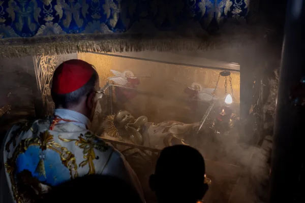 The Latin Patriarch of Jerusalem, Cardinal Pierbattista Pizzaballa, prays in front of the statue of Baby Jesus placed in the niche traditionally identified as the manger, in the Grotto of the Nativity, in Bethlehem. The prayer took place at the end of the Christmas Midnight Mass in the church of St. Catherine, presided over by the patriarch himself. Dec. 25, 2023. Credit: Marinella Bandini