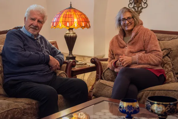 Eighty-year-old Garo Nalbandian, a professional photographer, and his wife, Hrout, sit on a couch in their living room. They risk losing the home they have lived in since 1969, where they have raised their children in a residential area of the Armenian Quarter close to the Cow’s Garden. Credit: Marinella Bandini