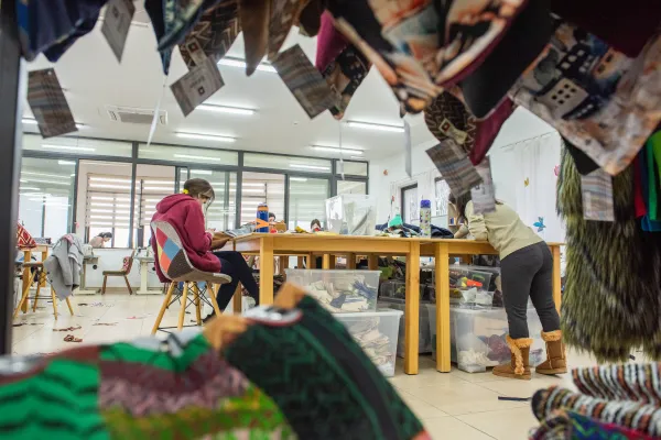 A view of the Rafedìn tailoring workshop in Amman, Jordan. The word “Rafedìn” means “the two rivers.” The rivers refer to the Tigris and the Euphrates, enclosing Mesopotamia, the land of Iraq. The name was chosen by the first Iraqi girls who participated in the project: approximately 20 young women who fled the persecution of ISIS in 2014. Credit: Marinella Bandini