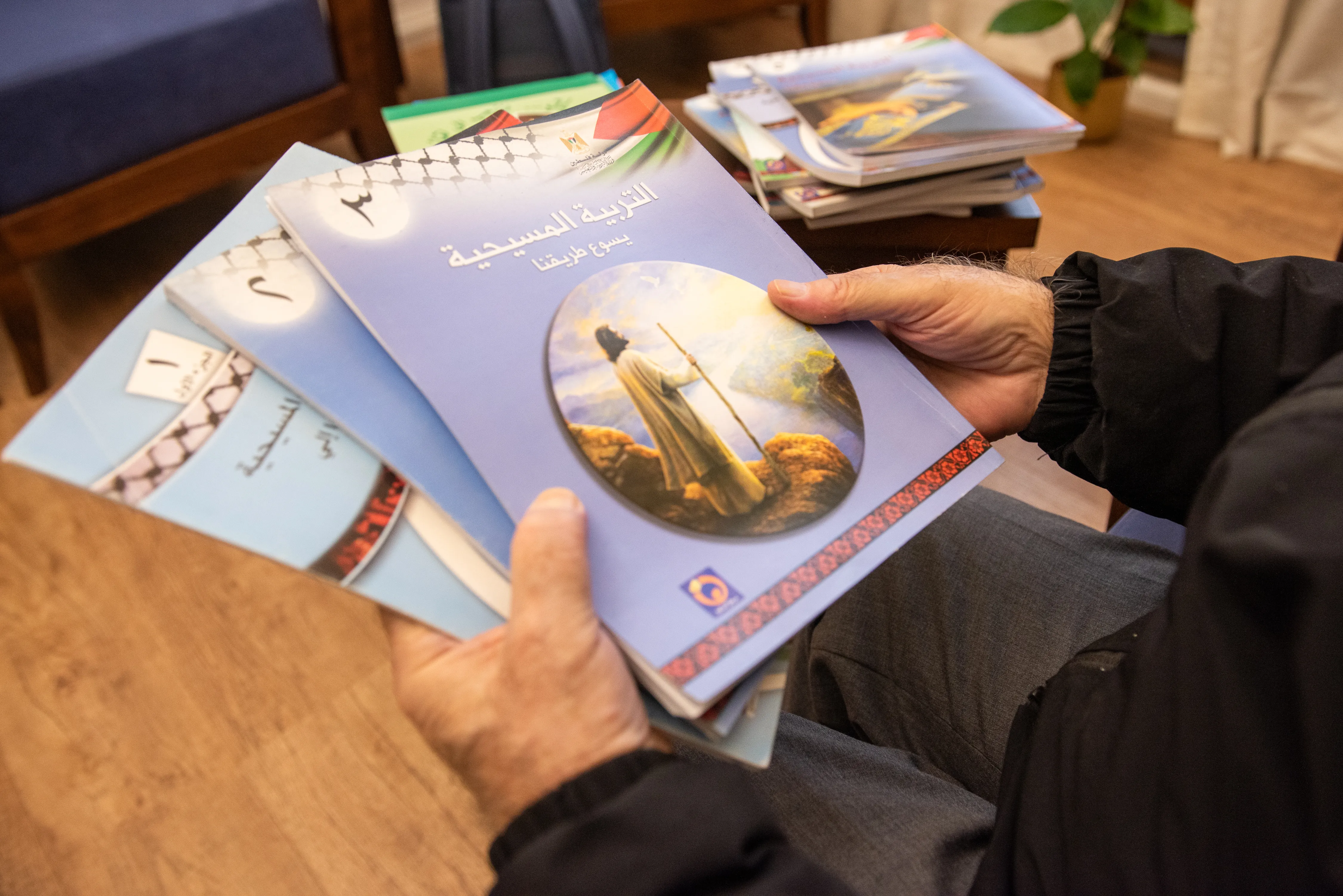 Father Rafiq Khoury at the beginning of the 2024 Week of Prayer for Christian Unity shows the first three volumes of the "ecumenical catechism" that was adopted in 2000 by public schools of the Palestinian Authority as a textbook for Christian education.?w=200&h=150