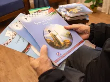 Father Rafiq Khoury at the beginning of the 2024 Week of Prayer for Christian Unity shows the first three volumes of the "ecumenical catechism" that was adopted in 2000 by public schools of the Palestinian Authority as a textbook for Christian education.