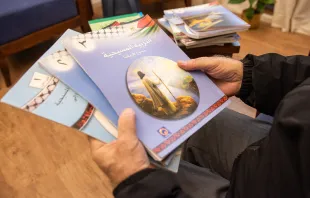 Father Rafiq Khoury at the beginning of the 2024 Week of Prayer for Christian Unity shows the first three volumes of the "ecumenical catechism" that was adopted in 2000 by public schools of the Palestinian Authority as a textbook for Christian education. Credit: Marinella Bandini
