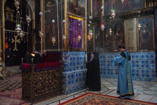 Armenski redovnik navlači ljubičasti zastor ispred jedne od ikona Djevice Marije koja se nalazi na stupovima koji obrubljuju svetište u armenskoj katedrali svetog Jakova u Jeruzalemu.  U subotu, 16. ožujka 2024., u armenskoj katedrali svetog Jakova u Jeruzalemu, tijekom službe 