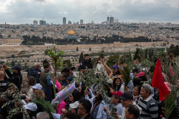 A group of participants in the Palm Sunday procession from Bethphage to Jerusalem on March 24, 2024, walk along the ridge of the Mount of Olives. From here, you can enjoy one of the most beautiful panoramas of Jerusalem. Credit: Marinella Bandini