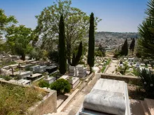 A view of the modern area of the Catholic cemetery located on the southern hillside of Mount Zion in April 2024. In the background are the buildings of the Arabic neighborhood of Abu Tor.