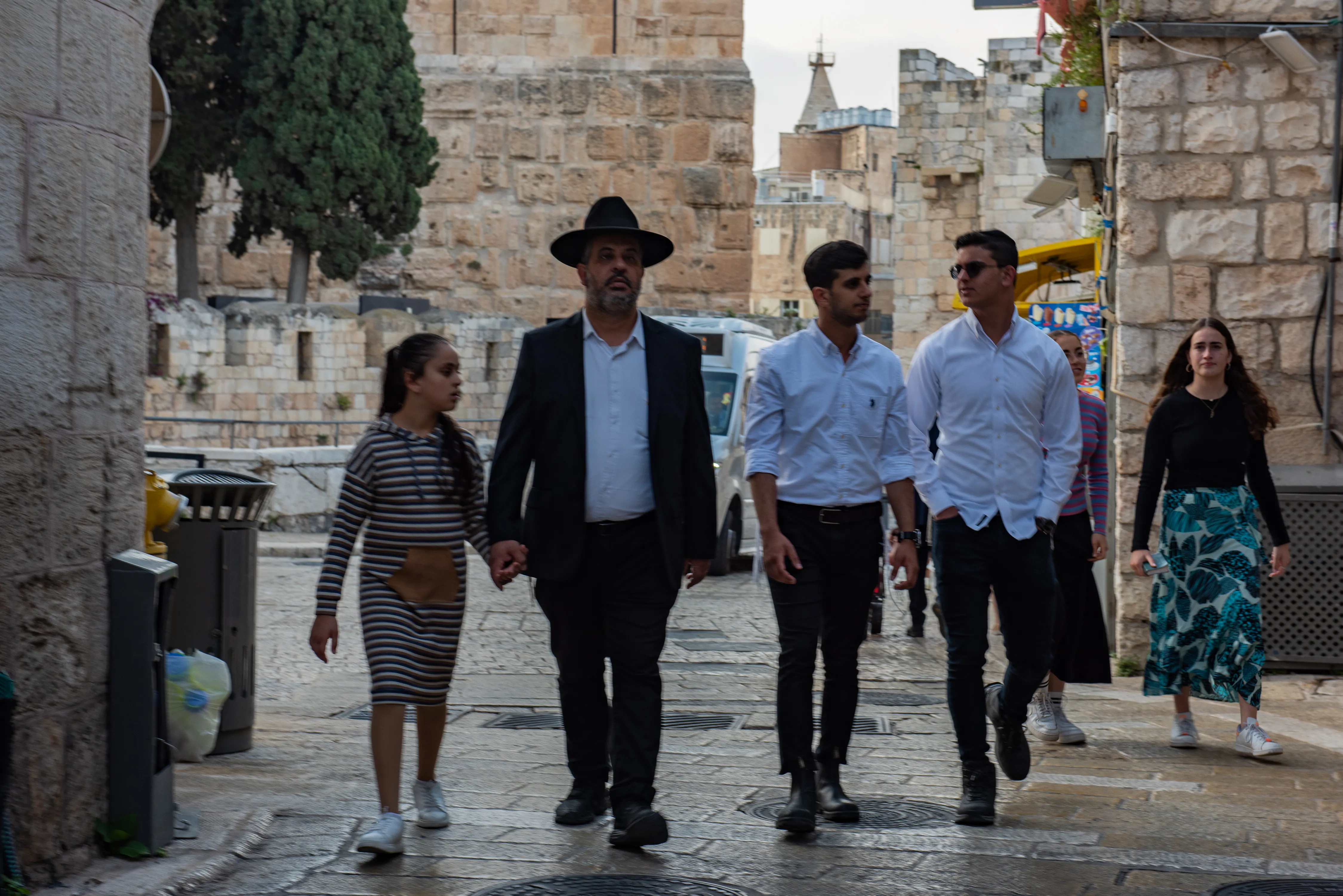 A family of religious Jews walks at the beginning of Armenian Quarter Street, the entry point to the Armenian Quarter of Jerusalem in April 2024. Behind them stands the complex of the Tower of David Museum.?w=200&h=150