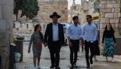 A family of religious Jews walks at the beginning of Armenian Quarter Street, the entry point to the Armenian Quarter of Jerusalem in April 2024. Behind them stands the complex of the Tower of David Museum.