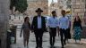 A family of religious Jews walks at the beginning of Armenian Quarter Street, the entry point to the Armenian Quarter of Jerusalem in April 2024. Behind them stands the complex of the Tower of David Museum.