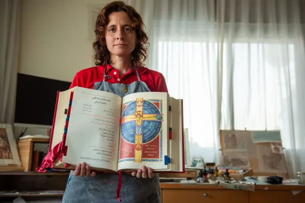 Iconographer María Ruiz Rodríguez with the new Roman Missal in Arabic. The book is open on the page where she depicted the Crucifixion of Jesus. Credit: Marinella Bandini
