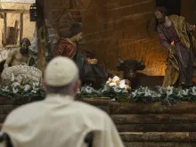 Pope Francis prays in front of the nativity scene after Christmas Mass Dec. 24, 2022.