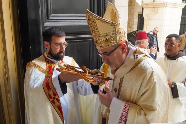 Cardinal Pierbattista Pizzaballa, Latin patriarch of Jerusalem, kisses the crucifix at the entrance of the Pro-Cathedral of the Latin Patriarchate, in Jerusalem, where he presided over the Mass of the solemnity of Mary, Mother of God, on Jan. 1, 2024. Credit: Courtesy of Latin Patriarchate of Jerusalem
