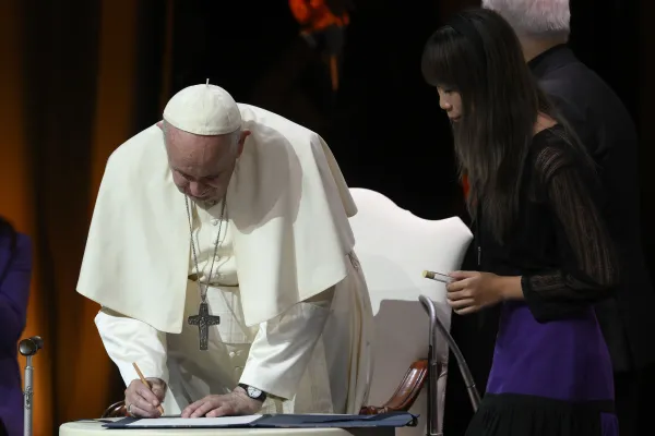 Pope Francis joins Economy of Francesco participants in signing a pact promoting an "economy of the Gospel" in Assisi, Italy, on Sept. 24, 2022. Vatican Media.