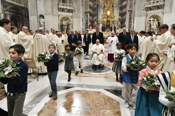 Pope Francis brings a figure of the Christ child over to the nativity scene inside of St. Peter’s Basilica at the end of Mass. Vatican Media