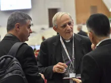 Cardinal Matteo Zuppi talks with other Synod on Synodality delegates at the general congregation assembly Oct. 9, 2023.