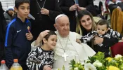 Pope Francis poses with a woman and three children during a lunch in the Vatican's Paul VI Hall for over 1,000 poor and economically disadvantaged people on Nov. 19, 2023.