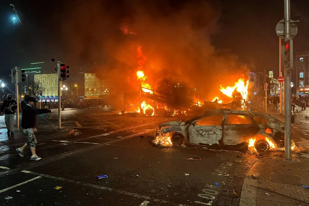 Flames rise from the car and a bus, set alight at the junction of Bachelors Walk and the O'Connell Bridge, in Dublin on Nov. 23, 2023, as people took to the streets following the stabbings earlier in the day.?w=200&h=150