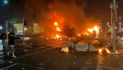 Flames rise from the car and a bus, set alight at the junction of Bachelors Walk and the O'Connell Bridge, in Dublin on Nov. 23, 2023, as people took to the streets following the stabbings earlier in the day.