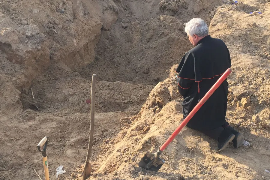 Papal envoy Cardinal Konrad Krajewski prays at a mass grave in Ukraine on Good Friday, April 15, 2022.?w=200&h=150